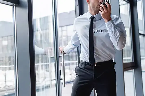 Agent de sécurité Casablanca patrouillant dans un immeuble de bureaux avec un talkie-walkie