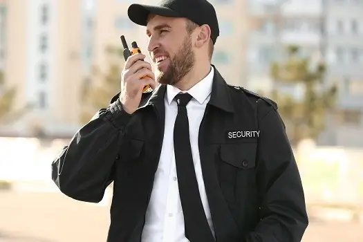 Un agent de sécurité tenant un talkie-walkie, prêt à communiquer et assurer gardiennage à Casablanca.